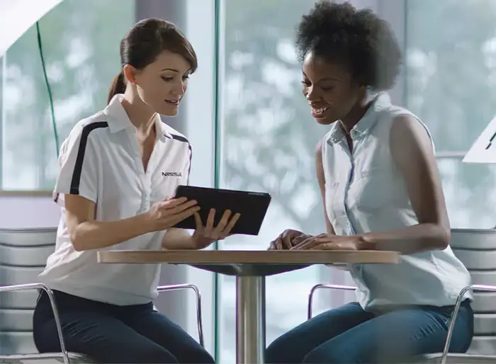 A dealership employee going over leasing options with a customer